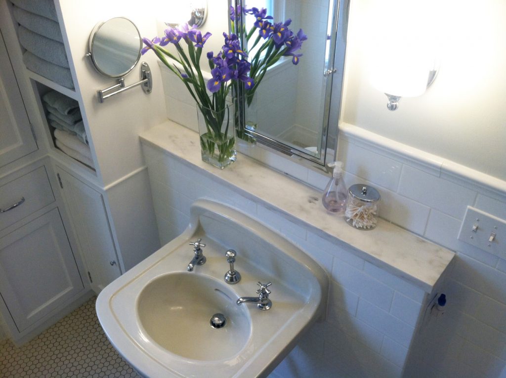A semi bird's-eye view of the sink and marble topped half wall.